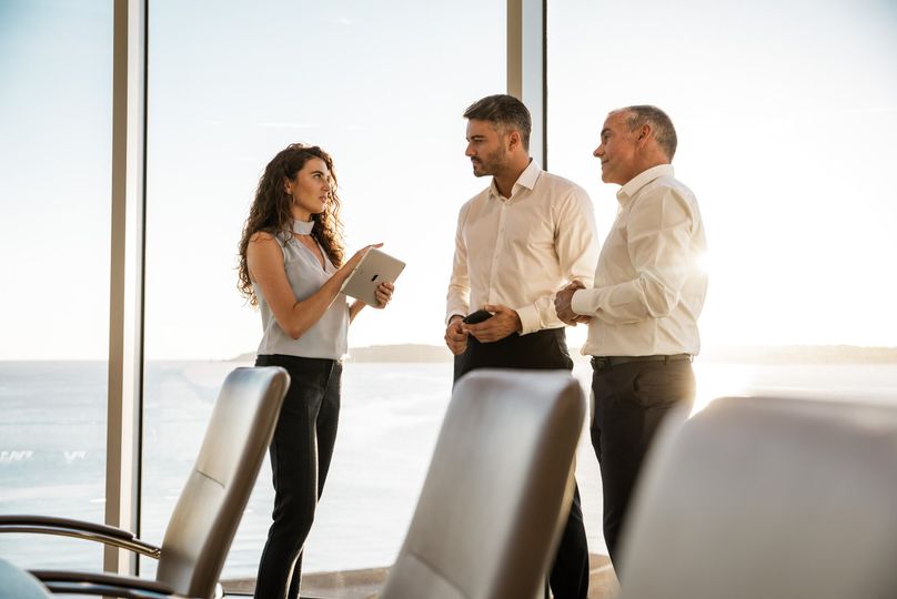 Businesspeople standing in office chatting
