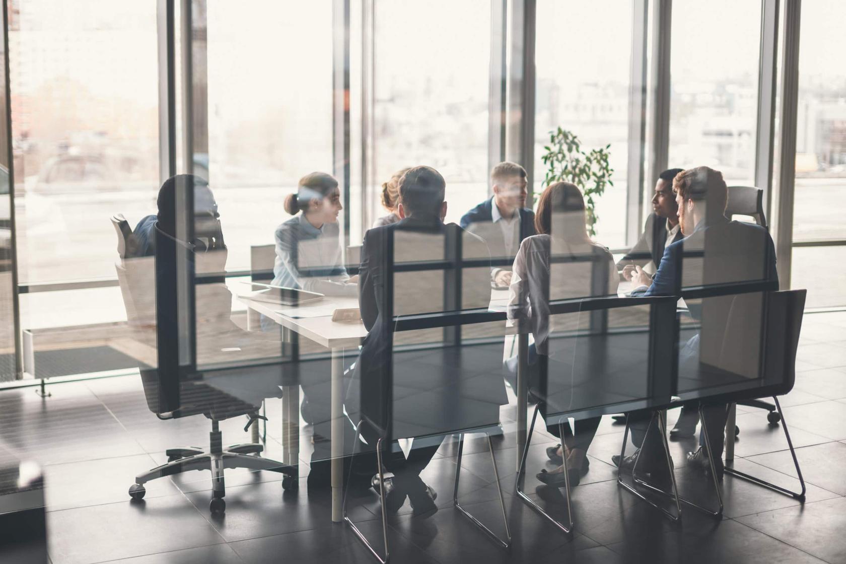 Group of businesspeople sitting around table in meeting room