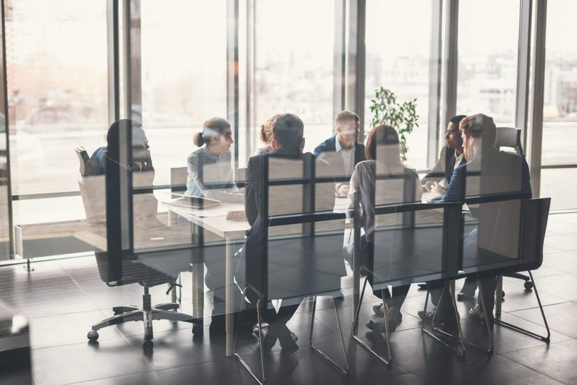 Group of businesspeople sitting around table in meeting room