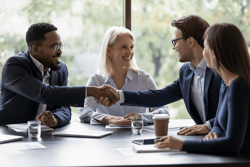 Smiling diverse businesspeople shake hands get acquainted greeting at customer meeting in office.