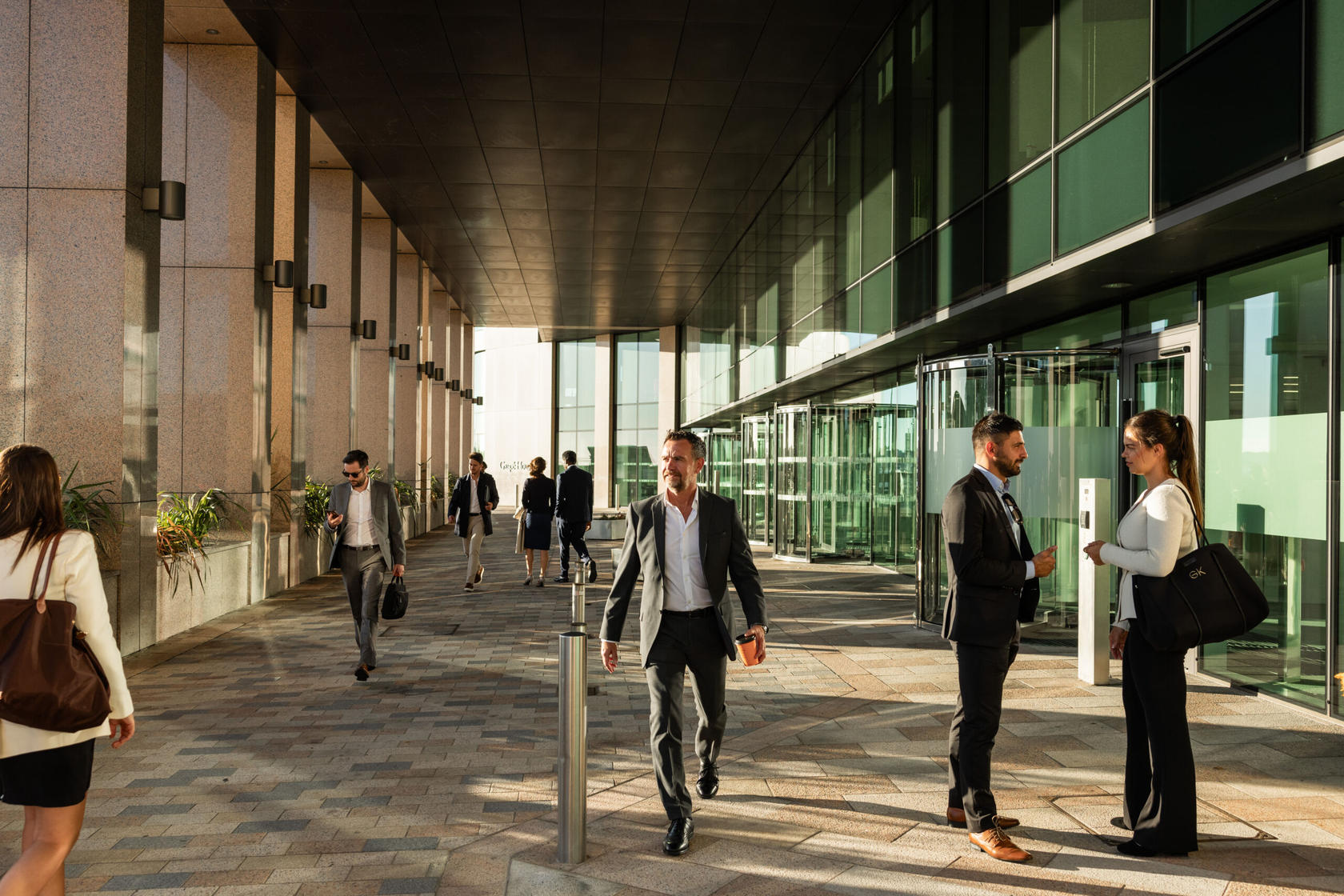 Business professionals walking and talking outside a modern office building.