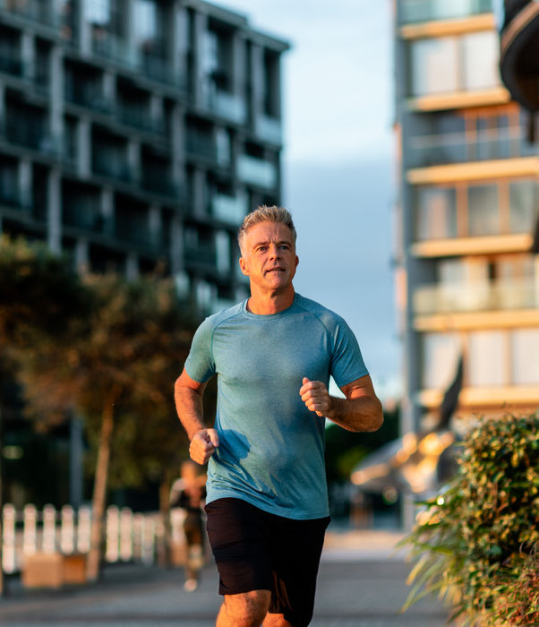Man jogging near the marina at sunrise