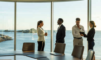A professional meeting in an office with a stunning seaside backdrop.