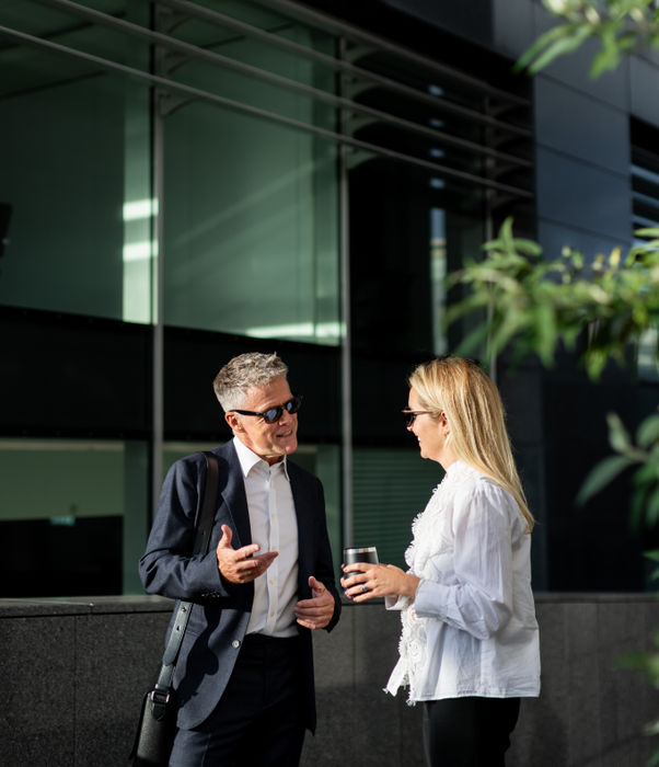 Casual conversation in front of a modern office building.