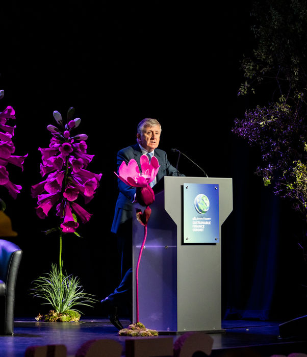 Joe Moynihan, Jersey Finance CE, stood behind a lectern on stage as he speaks at the 2025 Sustainable Finance summit
