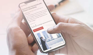 Two hands holding a mobile phone which has writing and a picture on its screen