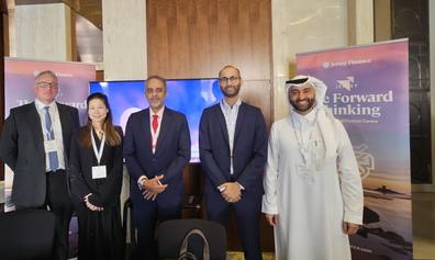 A line-up of business people in western and Arabic attire, standing in front of a table