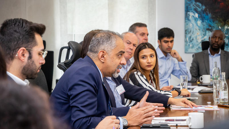 Faizal and other business people talking around a board table