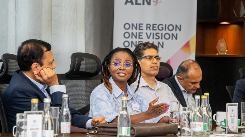 Rufaro addresses business people sitting around a table