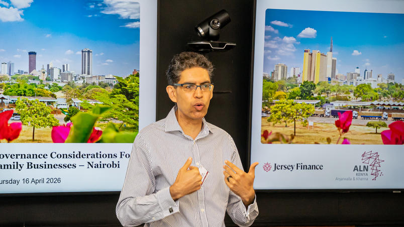 A bsuiness man talking in front of a screen with images of Nairobi